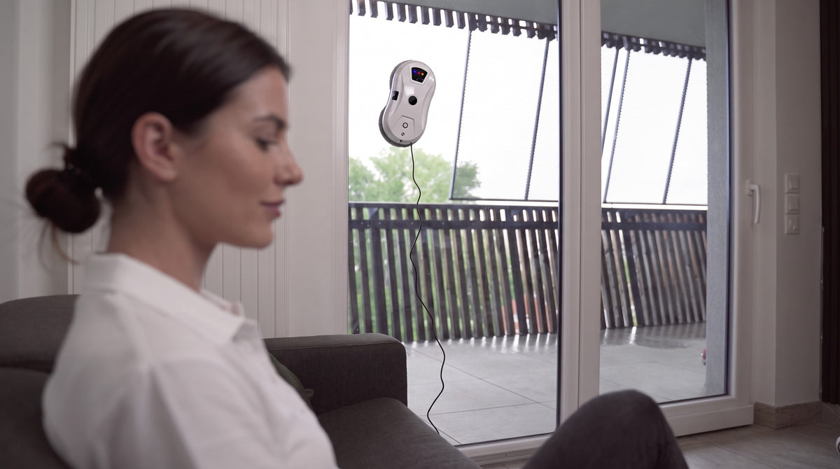 Robot lave-vitre LU PRO CLEAN blanc qui nettoie une baie vitrée